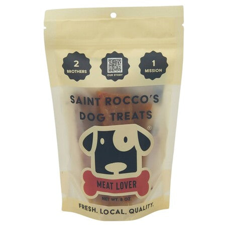 A 3 oz resealable stand-up pouch of Saint Rocco's Dog Treats 'Meat Lover' on a plain white background. The packaging is a warm cream/beige color with black text and a cartoon dog logo.