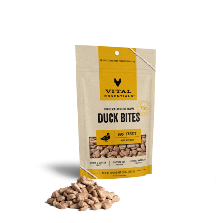 Vital Essentials freeze-dried raw Duck Bites dog treats in a small yellow-label pouch with treats in front.