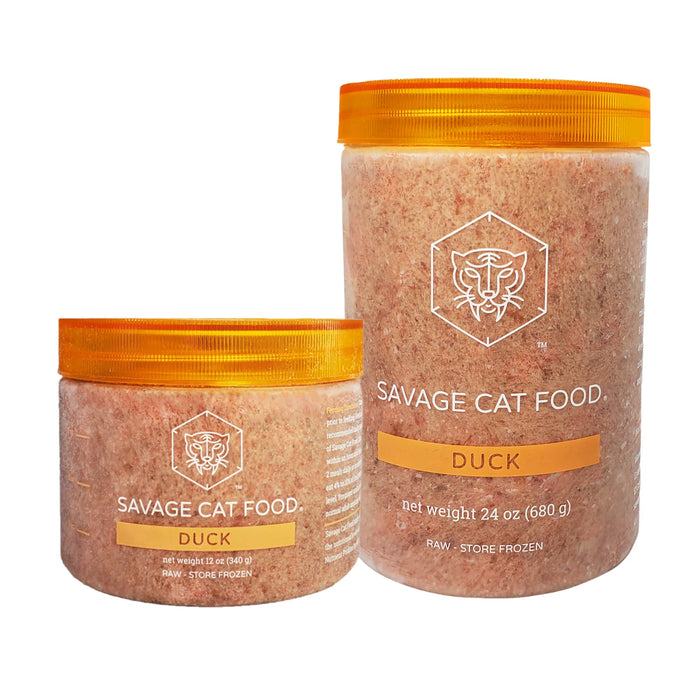 Two clear plastic jars of Savage Cat Food Duck, one 24 oz and one 12 oz, filled with pinkish-orange raw meat, featuring bright orange lids and white labels with a tiger logo.